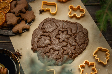 Rolled ginger dough and cookie cutters for making Christmas gingerbreads.