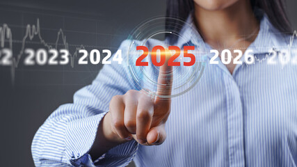 Woman presses the button with number 2025- copy space and bokeh for preparation merry Christmas and happy new year concept.