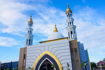 The splendor of the mosque and its towering minaret under the blue sky creates a stunning view