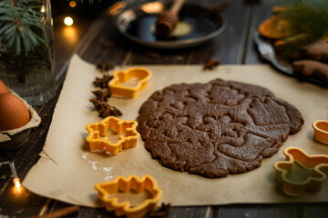 Making Christmas cookies. Rolled dough and cookie cutters on table.