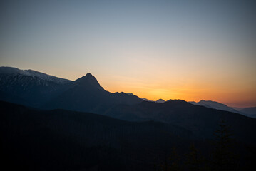 The sunset atop Mount Kopieniec in Zakopane, Poland, casts a warm glow over the Tatra Mountains, creating a stunning landscape 