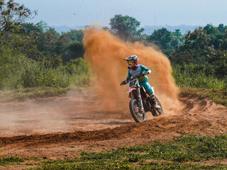 A biker creates a large cloud of dust and debris, Motocross concept