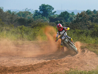A biker creates a large cloud of dust and debris, Motocross concept