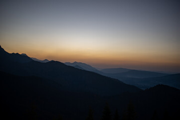 The sunset atop Mount Kopieniec in Zakopane, Poland, casts a warm glow over the Tatra Mountains, creating a stunning landscape