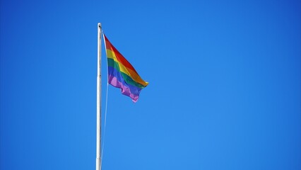 Winter Pride Maspalomas. Rainbow flags from the gay resort of Playa del Ingles in the Canary Islands flutter in the blue sky.