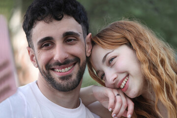 Fototapeta premium candid portrait of cute cheerful young couple taking selfie at the park 