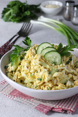 Salad with chicken, chinese cabbage, cucumber, boiled eggs and cheese in white bowl