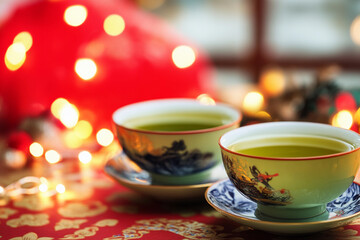 Fototapeta premium Green tea served in traditional cups with festive lights