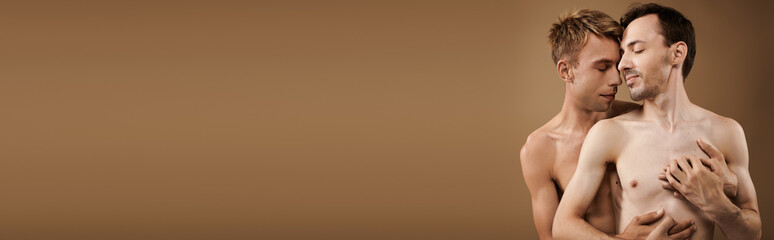 Fototapeta premium Two young men share a loving embrace, showcasing their affection in a cozy setting.