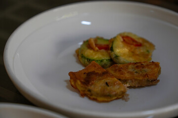a pancake made with fried food and baked pumpkins and various vegetables