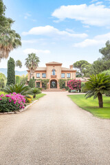 Obraz premium Beautiful estate with tropical landscaping and a welcoming pathway in a serene countryside setting