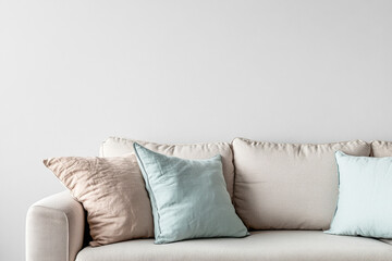 Cozy living room corner with a neutral sofa and soft pillows in a minimalist setting