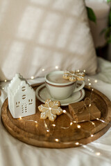 Christmas cozy home decor. Cookies, cup of cappuccino on wooden tray. Breakfast. Winter holidays.