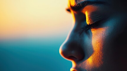 Close-up of a serene face at sunset, capturing a moment of reflection.