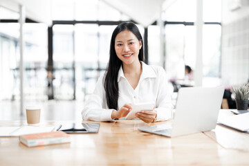 Young attractive businesswoman working on her project with laptop computer in modern office room.