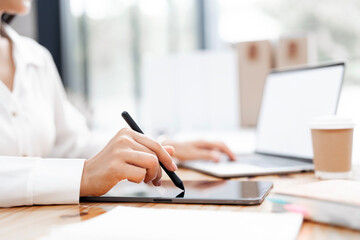Businesswoman using stylus pen signing contract on digital tablet working on laptop computer in modern office, electronic signature. Business man taking note
