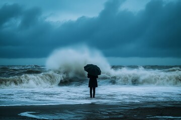 The dark silhouette of a person holding an umbrella faces powerful waves crashing onto the shore, set against a moody, overcast sky at dusk