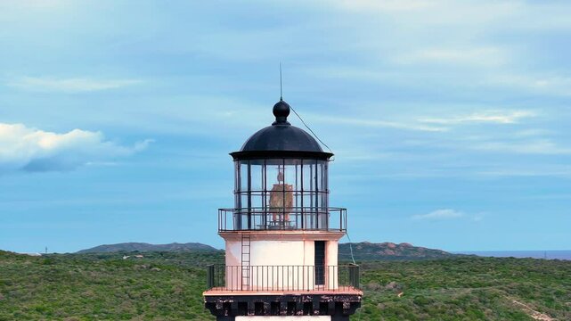 Exploring the historical lighthouse on the coast, surrounded by lush greenery and a stunning blue sky in the Caribbean landscape during a sunny afternoon