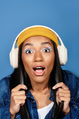 A young woman in chic autumn attire shows excitement while enjoying music with headphones on.