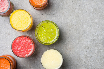 Glasses of fresh juice on gray stone table. Food background