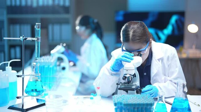 Scientist adjusting microscope in laboratory