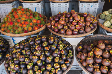 Mangosteen and rambutan are sold in wicker baskets in the Asian market