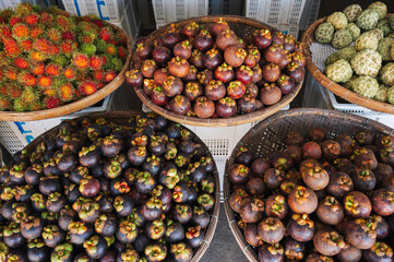Mangosteen and rambutan are sold in wicker baskets in the Asian market