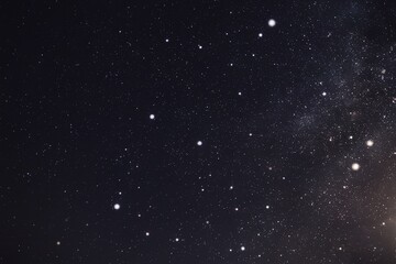 Fototapeta premium A night sky filled with numerous white dots, resembling stars or snowflakes