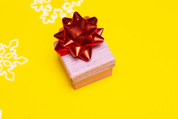 New year gift, space for present list. Gift box with red bow on yellow background.