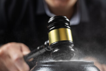 Judge hits a dusty table with a hammer, dust flies in all directions.