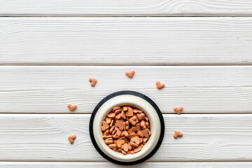 Bowl of biscuits for pets - food in a shape of heart, top view