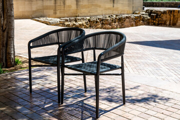 Two Black Chairs on a Cobblestone Patio in Open Space