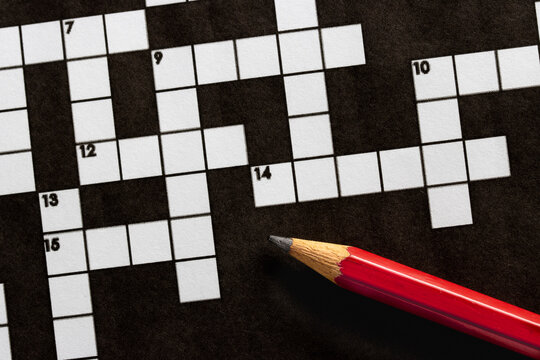 Empty, unfinished crossword puzzle, black and white crossword puzzle with a red pencil. On black background. 