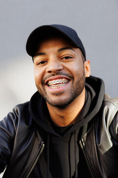 Portrait of smiling african american man with braces looking at camera outdoors