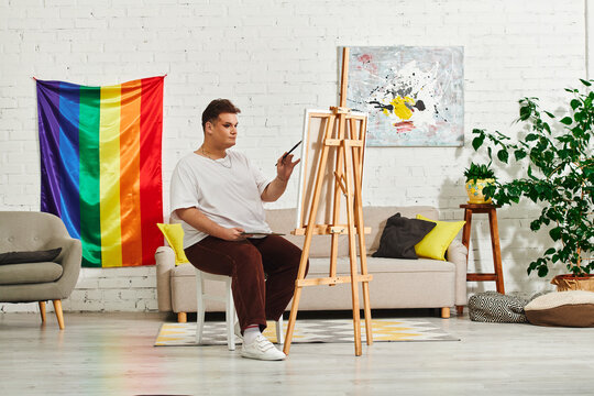In a cozy studio, a queer artist creates amid vibrant décor.
