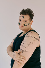 The queer person proudly reveals their body decorated with affirmations of love and identity.
