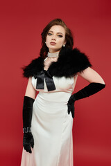 Fototapeta premium A stunning woman dressed in an elegant gown showcases her poise and style with a striking pose.