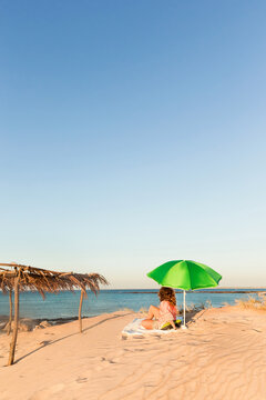Woman lying under a beach umbrella on the sands of cape leveque