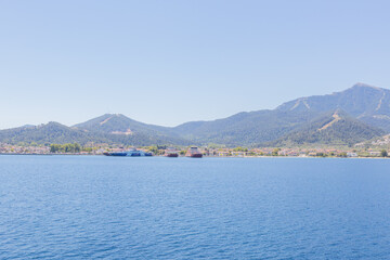 Fototapeta premium Ferry port at Thasos Island, Greece, with ferries docked and scenic mountain views in the background