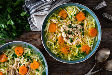 Broth - chicken soup with vegetables on wooden table
