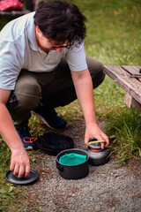 Camper Setting Up Cooking Gear Outdoors on Gravel Path