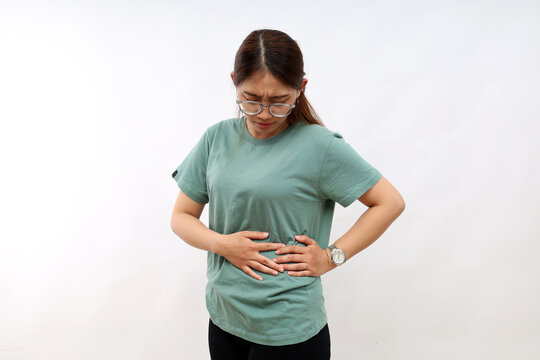 Asian woman's standing holding right stomach, suffering from stomach pain in the left side. Isolated on white