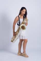 Full length portrait of a Venezuelan woman playing the saxophone looking at the camera