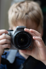 young boy taking a photo with a digital camera