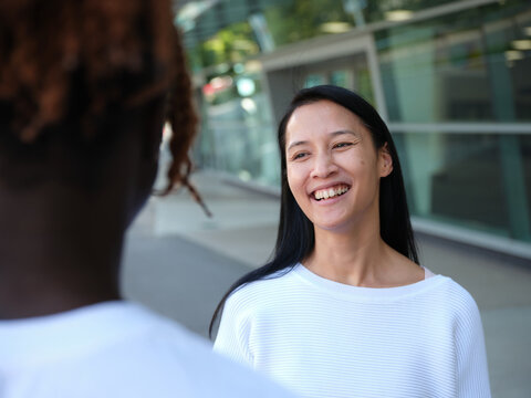 man standing in the street with an Asian woman smiling at him