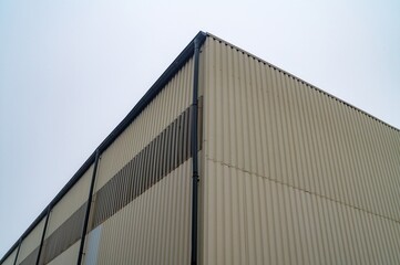 Corner of industrial building showing rain gutter and metal siding