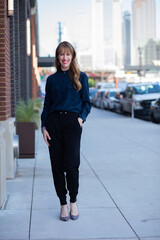 Beautiful woman standing on the sidewalk in the city