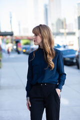 Beautiful woman standing on the sidewalk in the city