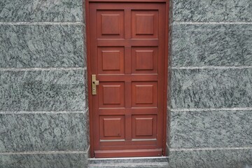 Brown wooden door in grey stone wall