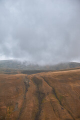 Dramatic mountain valley under a cloudy sky with a rugged landscape